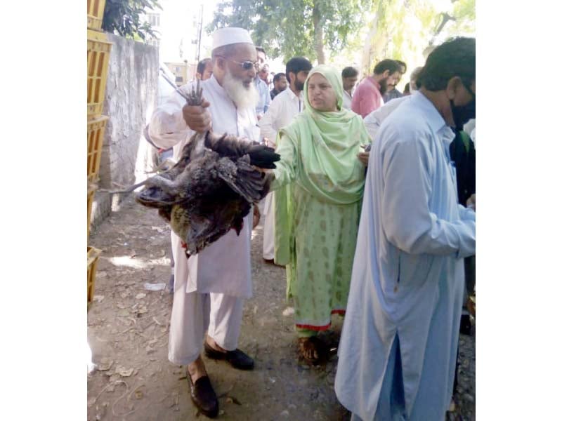 officials give chicken sets to people photo express