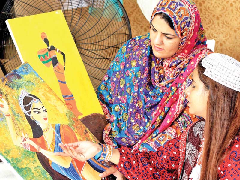 women look at paintings on display at lok virsa during rural women day photo nni