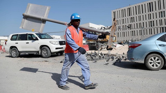 a migrant worker carries a pole at a construction site in the qatari capital doha ever since being chosen as the 2022 world cup host qatar 039 s labour laws have been internationally condemned and kafala has been at the heart of that criticism photo afp