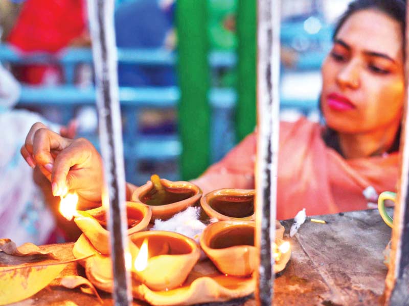 a woman lights a traditional oil lamp in lahore on the eve of data ganj baksh s 976th urs celebrations will begin on october 18 today and will end on october 20 photo online