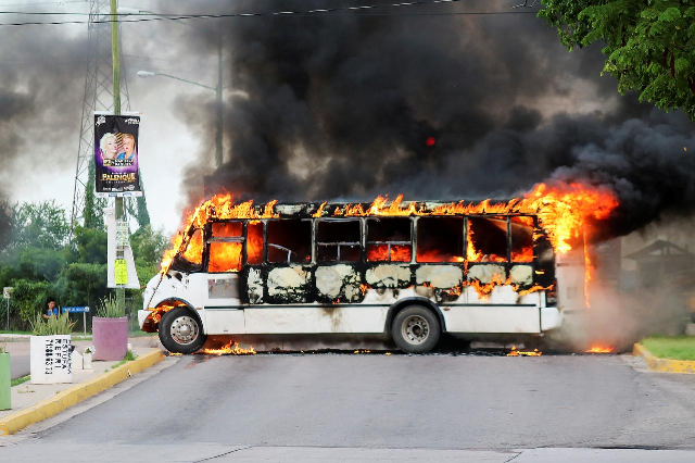 a burning bus set alight by cartel gunmen to block a road is pictured during clashes with federal forces following the detention of ovidio guzman photo reuters