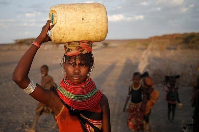 a woman carries a water canister in a village near loiyangalani kenya photo reuters file