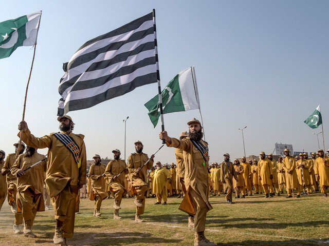 jui f activists hold the pakistani and their party flags as they prepare for azadi march in peshawar on october 13 2019 photo afp