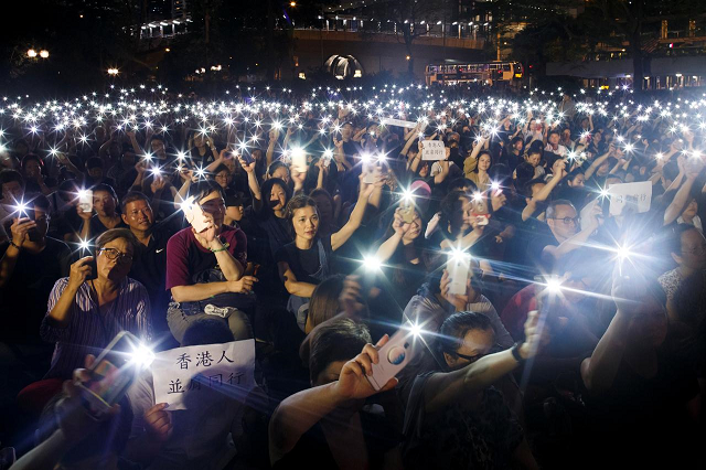 people wave flashlights during a gathering of hong kong mothers to show their support for the city s young pro democracy protesters in hong kong photo reuters