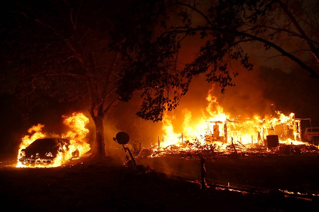 homes continue to burn after the fire moved through the area photo afp