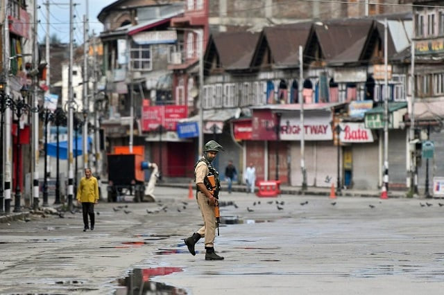 an indian security personnel patrols a deserted street in indian occupied kashmir photo afp an indian security personnel patrols a deserted street in indian occupied kashmir photo afp