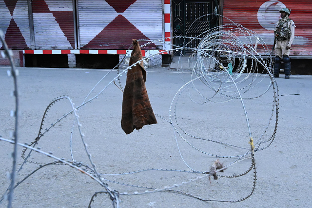 a security personnel stands guard on a street during a lockdown in srinagar photo afp