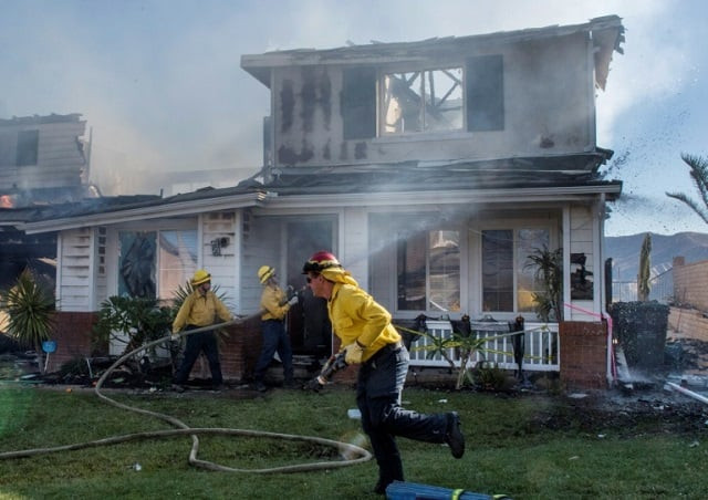 firefighters hose down a burning house during the tick fire in agua dulce near santa clarita california on october 25 2019 photo afp firefighters hose down a burning house during the tick fire in agua dulce near santa clarita california on october 25 2019 photo afp