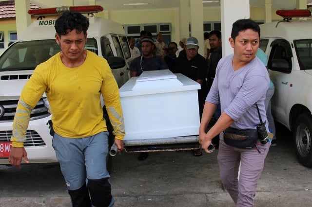 local hospital officials and family members carry the coffin of a motorcycle driver in intan jaya district papua on october 26 2019 who was killed after being shot dead by armed rebels prior to indonesia 039 s president visit to the restive province photo afp