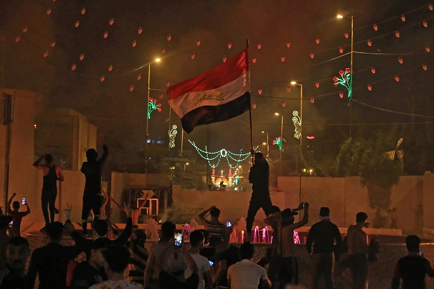 an iraqi protester waves the national flag during an anti government demonstration in the shiite shrine city of karbala south of iraq 039 s capital baghdad photo afp