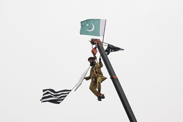 a jui f supporter is seen on crane holding the party 039 s and national flags in lahore on wednesday photo reuters a jui f supporter is seen on crane holding the party 039 s and national flags in lahore on wednesday photo reuters