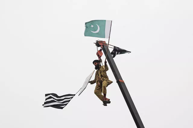 a jui f supporter is seen on crane holding the party 039 s and national flags in lahore on wednesday photo reuters a jui f supporter is seen on crane holding the party 039 s and national flags in lahore on wednesday photo reuters