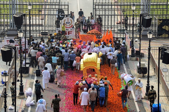 sikh priest carries the guru granth sahib sikh holy book along with devotees during the 039 nagar kirtan 039 procession before crossing over to pakistan at wagah border photo afp