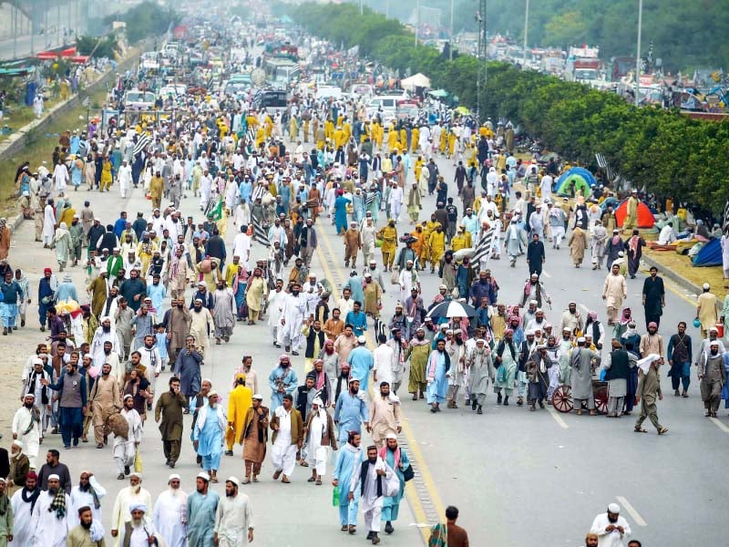 azadi march participants walk down the kashmir highway in islamabad as they head to the protest venue photo agencies