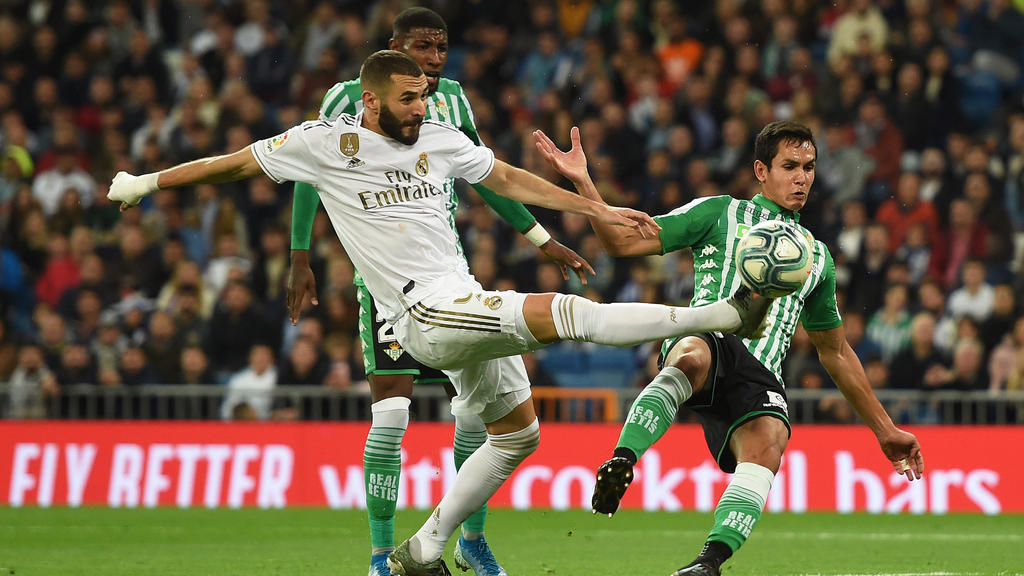 karim benzema of real madrid cf connects with a cross beside mandi of real betis balompie photo afp