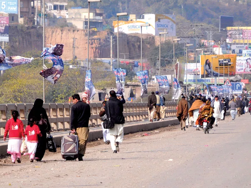 motorcyclists find a unique way to get passed a barricade at soan bridge while commuters were forced to walk beyond this point photo waseem nazir express