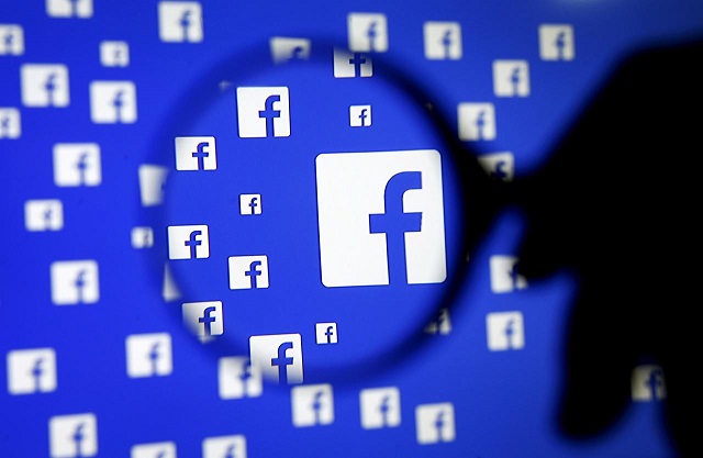 a man poses with a magnifier in front of a facebook logo on display in this illustration taken in sarajevo bosnia and herzegovina december 16 2015 photo reuters