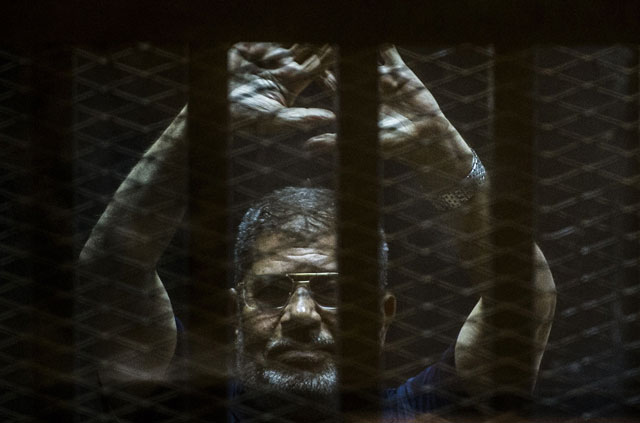 a file picture taken on june 2 2015 shows ousted egyptian president mohamed morsi gesturing from the defendants cage as he attends his trial at the police academy on the outskirts of the capital cairo photo afp