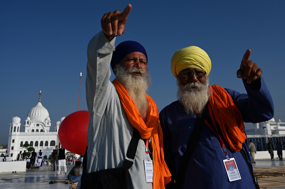 sikh pilgrims point at the inauguration site of the shrine of baba guru nanak dev at gurdwara darbar sahib in kartarpur on november 9 2019 photo afp