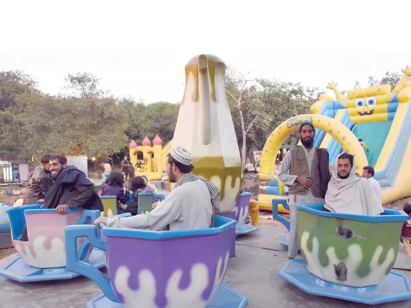 azadi march participants take a break to enjoy rides at a recreation park in islamabad photo online azadi march participants take a break to enjoy rides at a recreation park in islamabad photo online