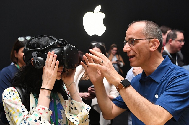 an apple employee helps a member of the media try on an htc vive while testing the virtual reality capabilities of the new imac during apple 039 s worldwide developers conference in san jose california on june 5 2017 photo afp