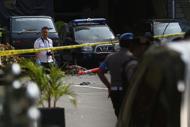 police keep watch near the blast location after a suspected suicide bombing outside the police headquarters in medan photo reuters