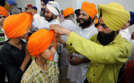 sikh children have turbans tied over their heads during a gathering for world turban day photo afp file