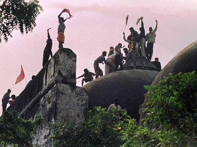 a photo taken on december 6 1992 shows hindus shouting and waving banners as they stand on the top of a stone wall and celebrate the destruction of the 16th century babri mosque in ayodhya photo afp