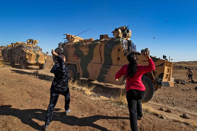 kurdish demonstrators hurl rocks at a turkish military vehicle on november 8 2019 during a joint turkish russian patrol near the town of al muabbadah in the northeastern part of hassakah on the syrian border with turkey photo afp