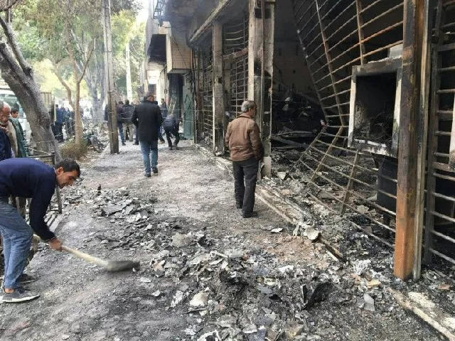 iranians walk past a bank that was set on fire by protesters during a demonstration against a rise in gasoline prices in isfahan on november 17 photo afp iranians walk past a bank that was set on fire by protesters during a demonstration against a rise in gasoline prices in isfahan on november 17 photo afp
