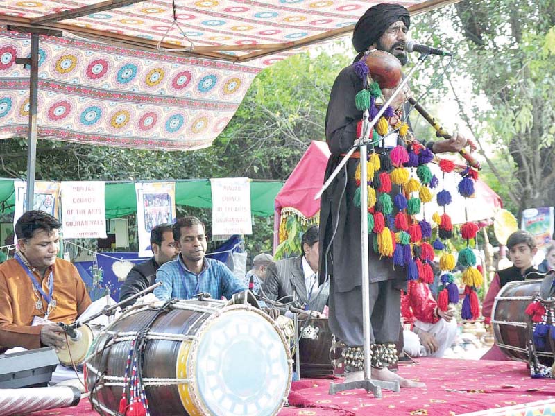 a folk singer performs on stage during folk festival at lok virsa photo app