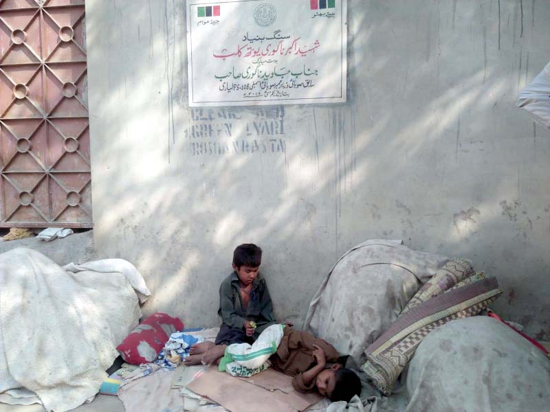 these children seated among blankets and other household goods are on guard protecting their families belongings in the absence of elders most of whom work all day long as daily wage labourers photo express