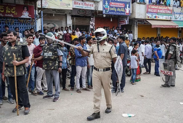 police officers stand guard as people attend a protest against the alleged rape and murder of a 27 year old woman in shadnagar on the outskirts of hyderabad india photo reuters police officers stand guard as people attend a protest against the alleged rape and murder of a 27 year old woman in shadnagar on the outskirts of hyderabad india photo reuters