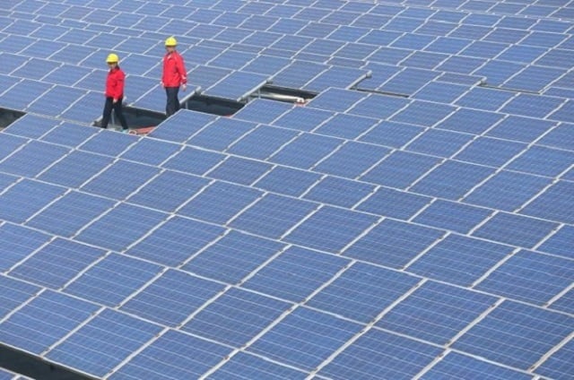 workers walk past solar panels in jimo shandong province china april 21 2016 photo reuters