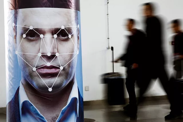 file photo people walk past a poster simulating facial recognition software at the security china 2018 exhibition on public safety and security in beijing china october 24 2018 photo reuters file photo people walk past a poster simulating facial recognition software at the security china 2018 exhibition on public safety and security in beijing china october 24 2018 photo reuters