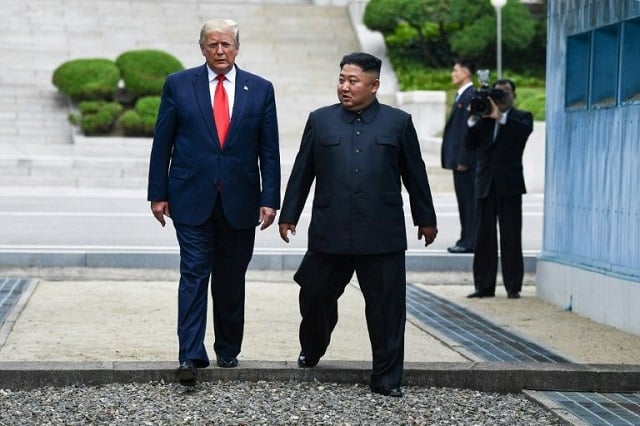 north korea 039 s leader kim jong un and us president donald trump cross south of the military demarcation line that divides north and south korea after trump briefly stepped over to the northern side on june 30 2019 photo afp