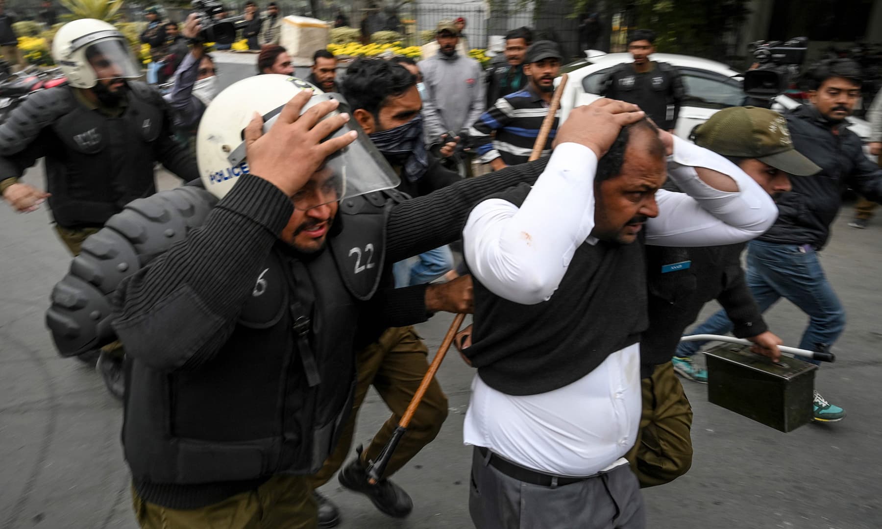 policemen detain a lawyer r following a clash between lawyers and doctors in lahore on wednesday afp