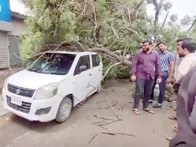 people look at an uprooted tree that fell on a car in karachi which experienced strong winds due to cyclone asna in the arabian sea on friday photo ppi people look at an uprooted tree that fell on a car in karachi which experienced strong winds due to cyclone asna in the arabian sea on friday photo ppi