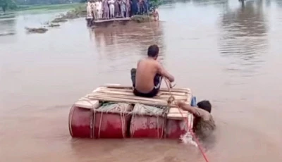 a rope is being used to help stranded people cross a flooded road in narowal photo nni
