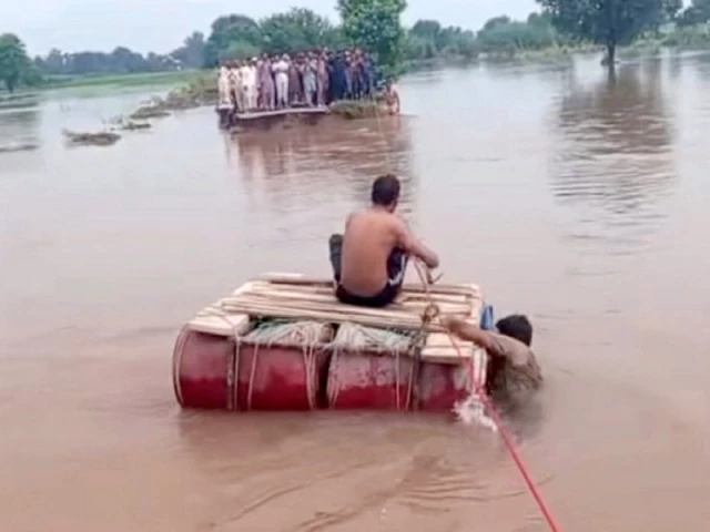 a rope is being used to help stranded people cross a flooded road in narowal photo nni a rope is being used to help stranded people cross a flooded road in narowal photo nni