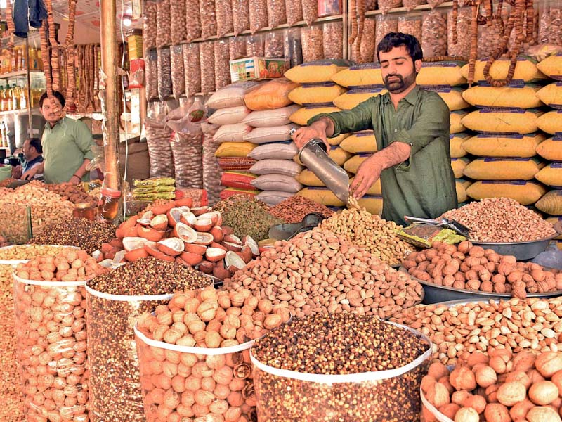 a shopkeeper arranges dried fruits at his shop in islamabad photo online