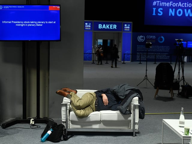a man sleeps during the un climate change conference cop25 at the 039 ifema feria de madrid 039 exhibition centre in madrid on december 15 2019 photo afp a man sleeps during the un climate change conference cop25 at the 039 ifema feria de madrid 039 exhibition centre in madrid on december 15 2019 photo afp