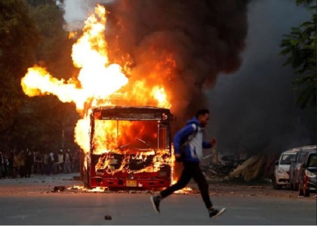 a man runs past a burning bus that was set on fire during demonstrations against india 039 s new citizenship law photo reuters