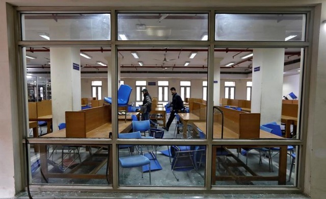 people walk inside a partially damaged library of the jamia millia islamia university after police entered the university campus on the previous day following a protest against a new citizenship law in new delhi india december 16 2019 photo afp