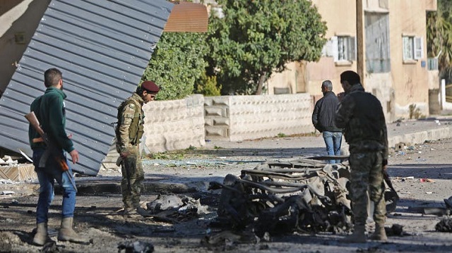 turkish backed syrian fighters stand at the scene of a car bomb explosion in ras al ain on december 4 2019 photo afp