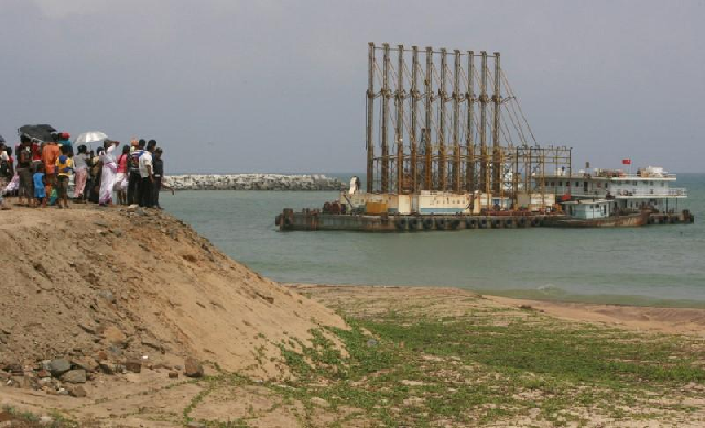 a group of sri lankan visitors at the deep water shipping port watch chinese dredging ships work in hambantota photo reuters