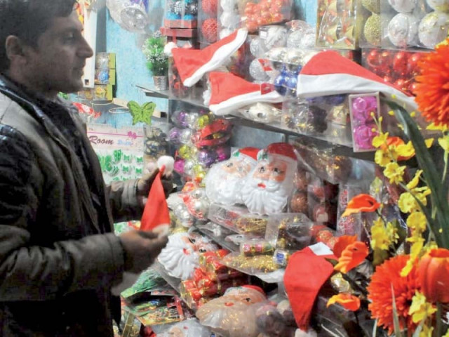 a man arranges christmas decorations while a girl looks at christmas tree at france colony in islamabad photos express online a man arranges christmas decorations while a girl looks at christmas tree at france colony in islamabad photos express online