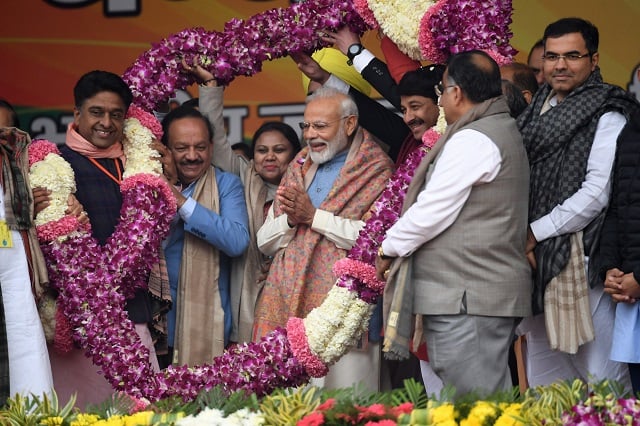 india 039 s prime minister narendra modi c is greeted with a garland of flowers upon his arrival for a rally in new delhi on december 22 photo afp