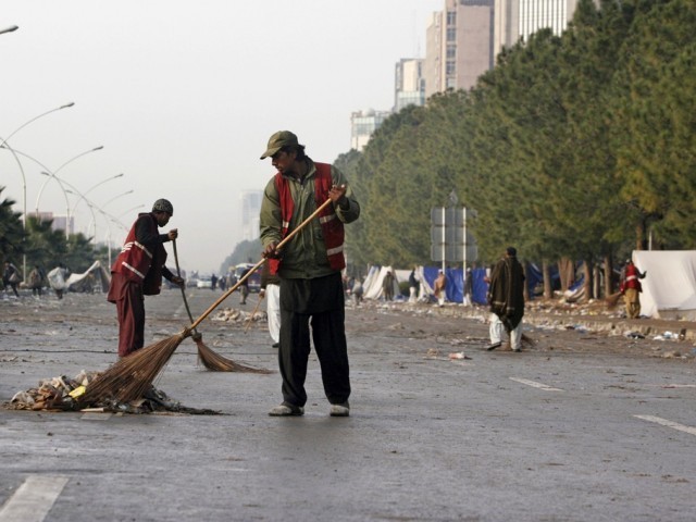 a reuters file photo of workers cleaning up a karachi road