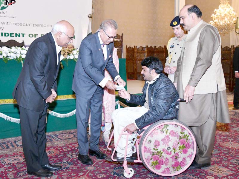 president arif alvi presents a cheque to specially baled person photo express